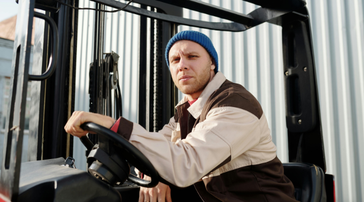 Man driving a truck in a beanie and jacket